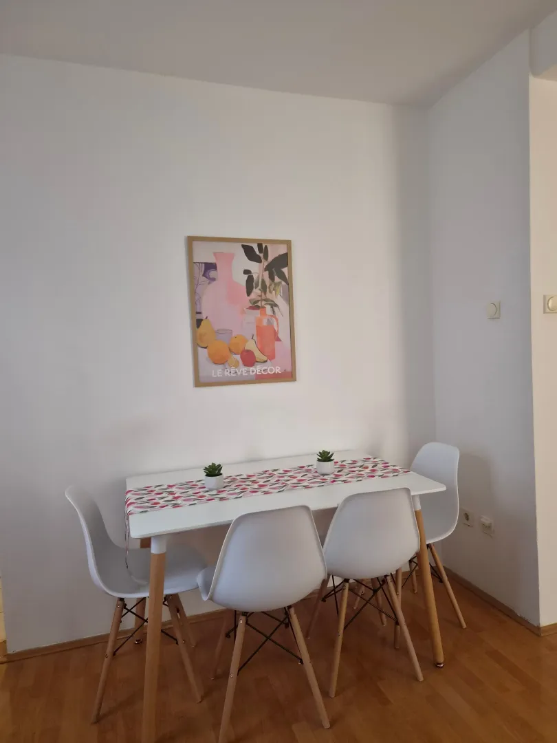 Dining area with a white table and four chairs.