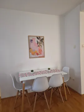 Dining area with a white table and four chairs. - image 4