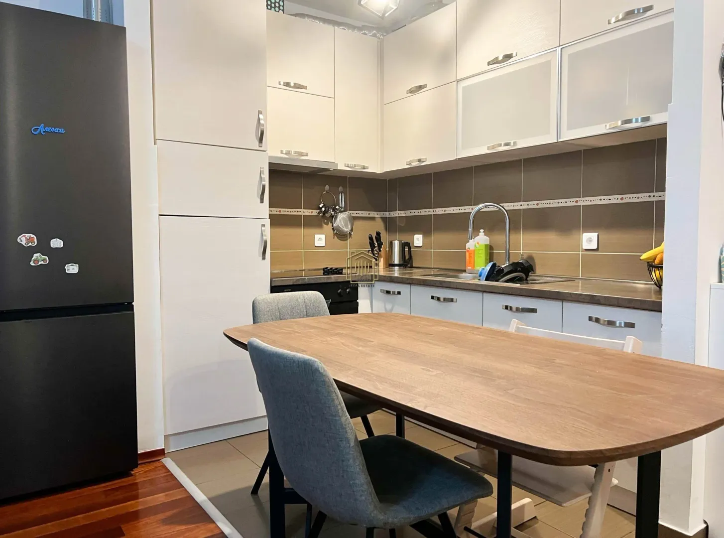 Kitchen with white cabinets and a dining table with chairs.