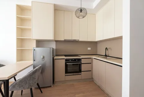 Modern kitchen with beige cabinets, built-in appliances, and a dining area. - image 3