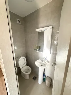 Manje kupatilo sa wc šoljom, umivaonikom i ormarićem sa ogledalom. - image 4