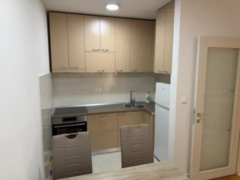 Small kitchen with beige cabinets and a built-in oven. - image 4
