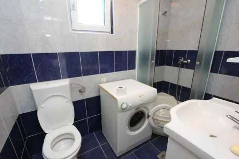 Jednostavno kupatilo sa tuš kabinom, veš mašinom i plavim pločicama. - image 13
