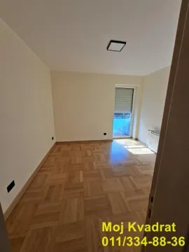 Prazna soba sa parketom i vratima koja vode na terasu. - image 10