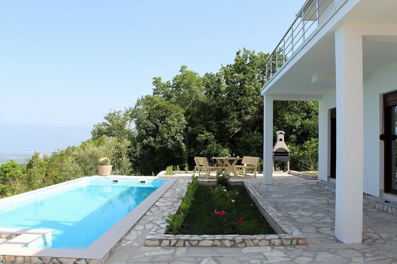 Exterior of the house with a swimming pool, terrace, and seating area.