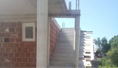 Exterior of a house under construction showing concrete stairs. - image 4