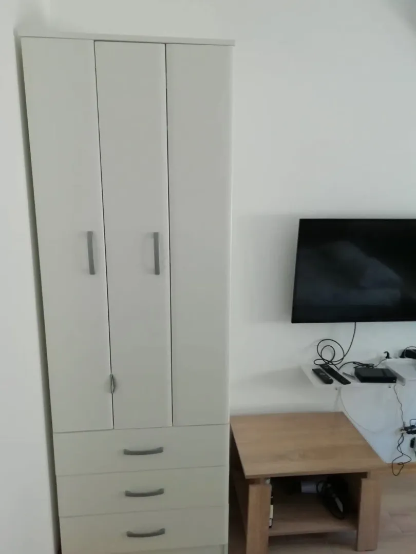 Spavaća soba sa ormarom i televizorom.