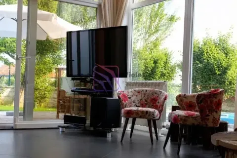 Living room with a TV, armchairs and large glass surfaces overlooking the yard. - image 10