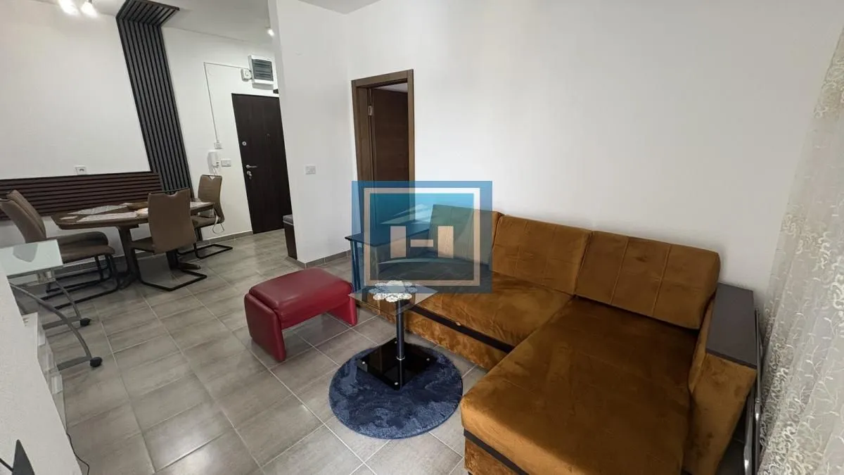 Living room with a sectional sofa, a coffee table, and a dining area in the background.