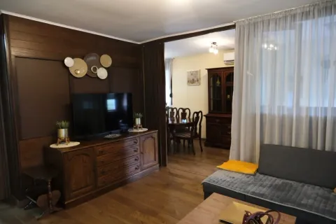 Living room with wooden furniture and a TV. - image 10