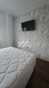 Spavaća soba sa bračnim krevetom i televizorom na zidu. - image 5