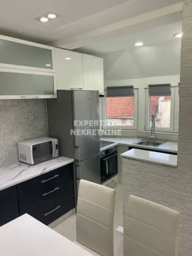 Modern kitchen with white and dark cabinets and a dining table. - image 6