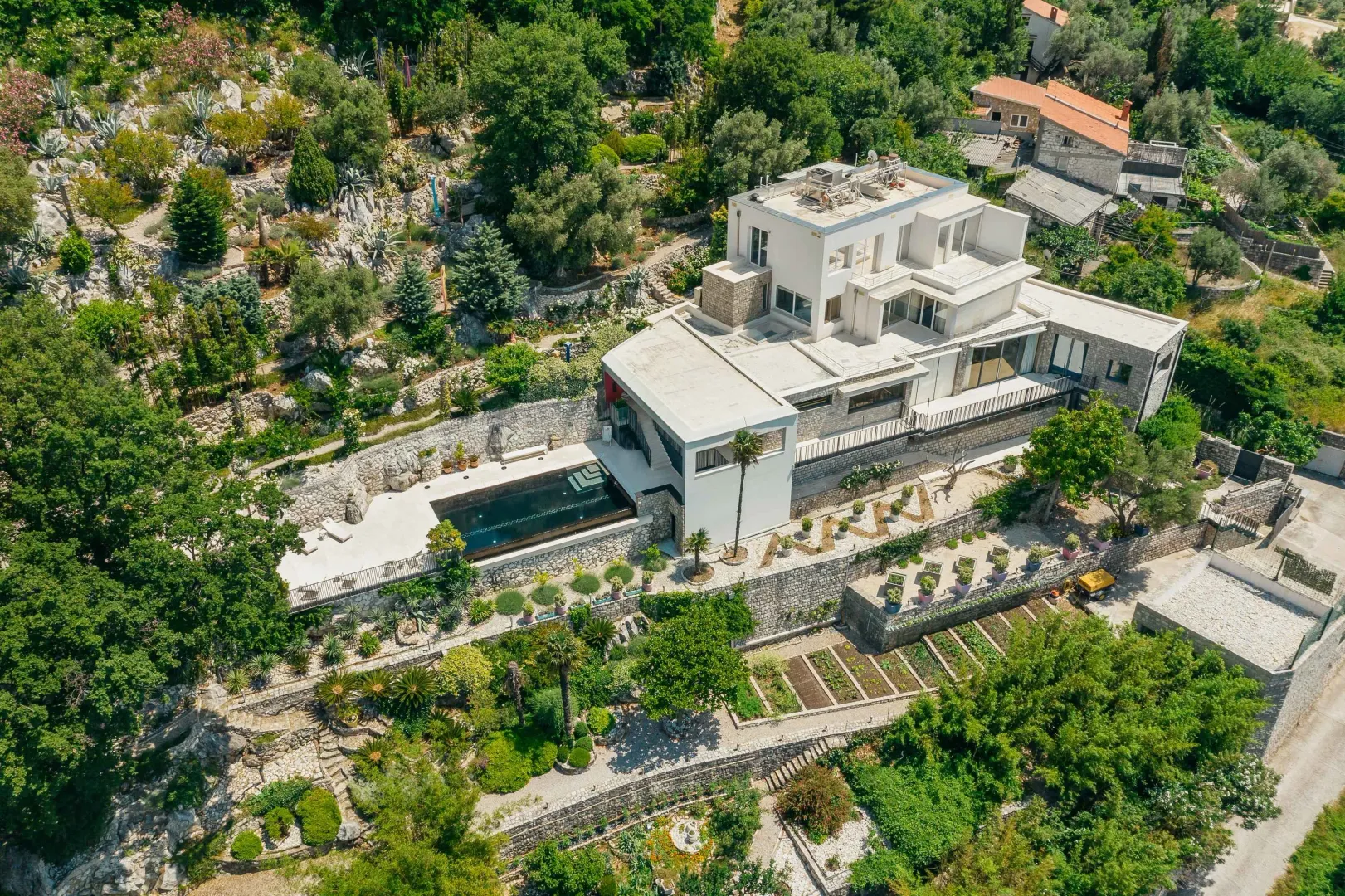 Pogled iz vazduha na modernu vilu sa bazenom i uređenim dvorištem.