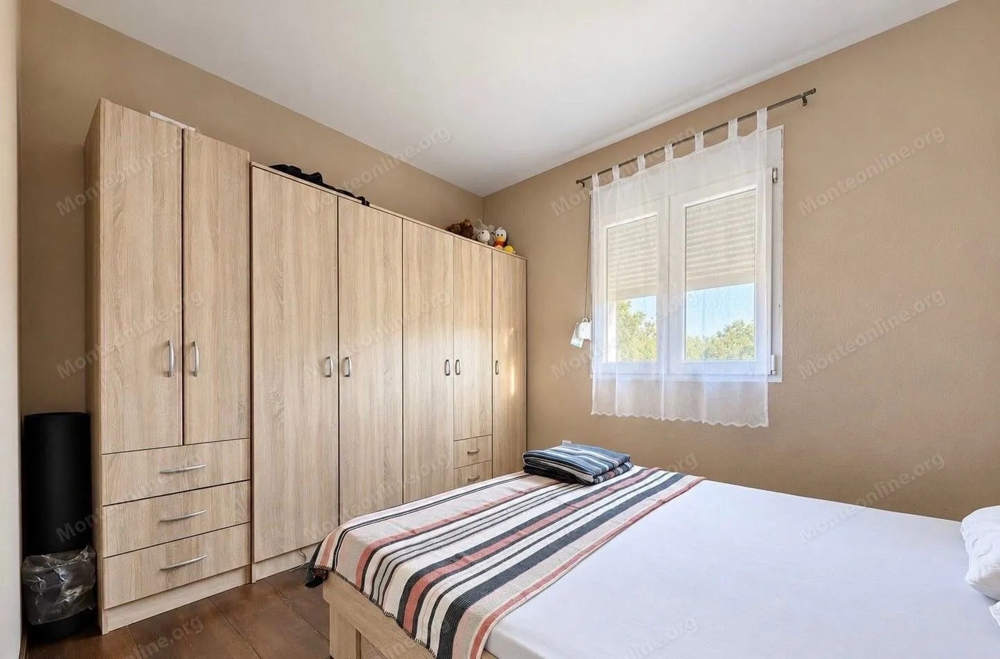 Furnished bedroom with a large wardrobe and a double bed.