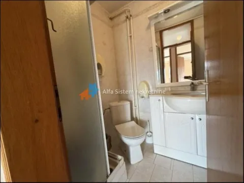 Smaller bathroom with a shower cabin, sink, and toilet. - image 11