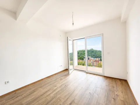 Prazna svijetla soba sa drvenim podom i balkonskim vratima. - image 10