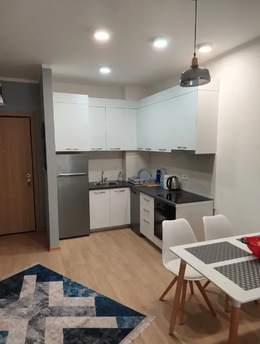 Modern kitchen with white cabinetry and a dining table.