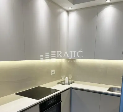 Modern kitchen with white cabinets and a built-in cooktop. - image 7