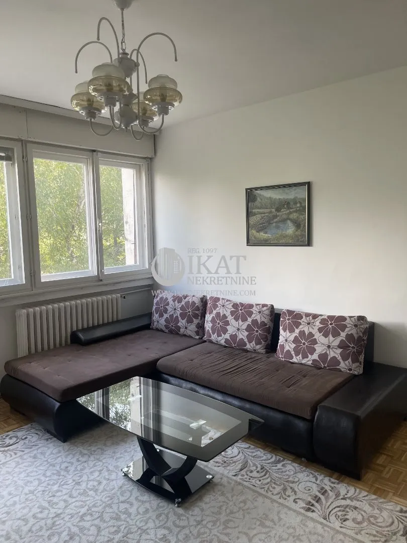 Living room with a sectional sofa, coffee table and a window.