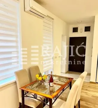 Dining area with a table, chairs, and windows. - image 2