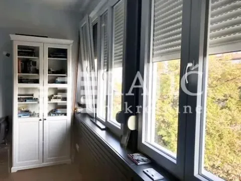 Living room with a white bookcase and large windows. - image 15