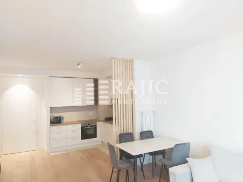 Living room with dining area and kitchen in bright tones. - image 3