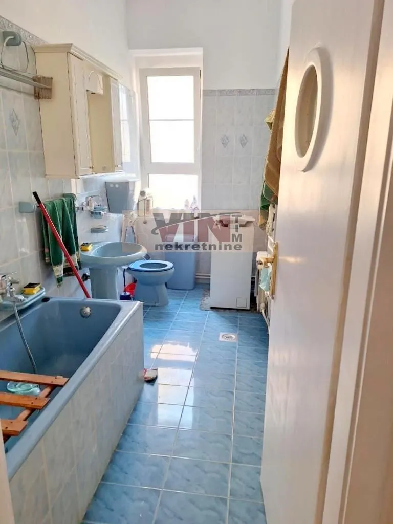 Kupatilo sa plavim pločicama, kadom, umivaonikom i WC šoljom.