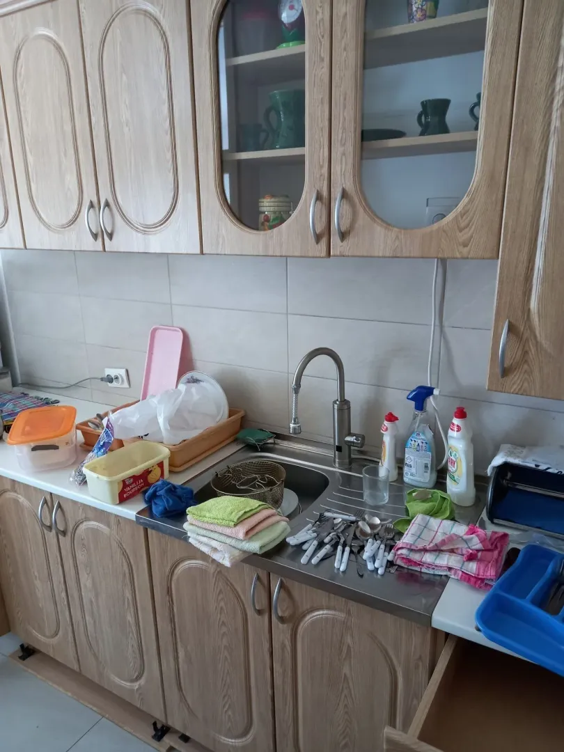 Kuhinja sa drvenim elementima i sudoperom.