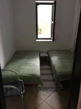 Mala spavaća soba sa dva singl kreveta i prozorom. - image 7