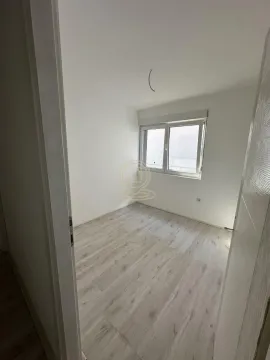 Prazna soba sa laminatom i prozorom, uslikana sa vrata. - image 6
