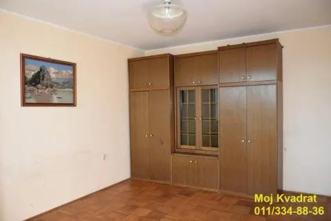 Dnevna soba sa drvenim garderoberom i parketom na podu. - image 7
