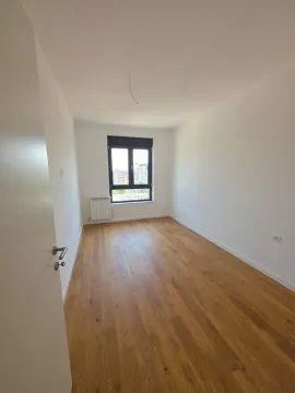 Prazna soba sa belim zidovima i drvenim podom. - image 10