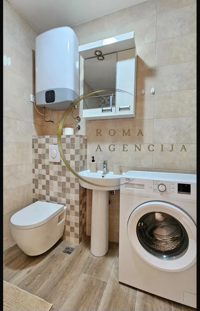 Manje kupatilo sa sanitarijama, bojlerom i veš mašinom.