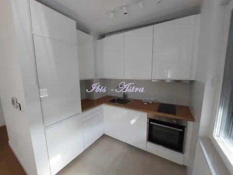 Moderna kuhinja sa belim elementima i drvenom radnom pločom. - image 4