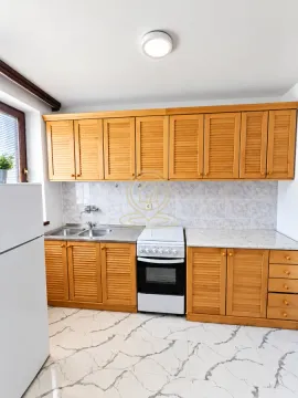 Kitchen with wooden cabinetry, stove, and refrigerator. - image 5