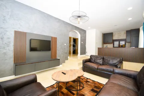 Living room with sofa set, TV and a view of the kitchen in the background. - image 10