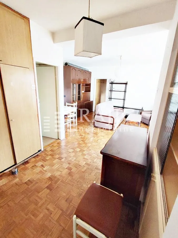 Living room with wooden furniture and parquet flooring.