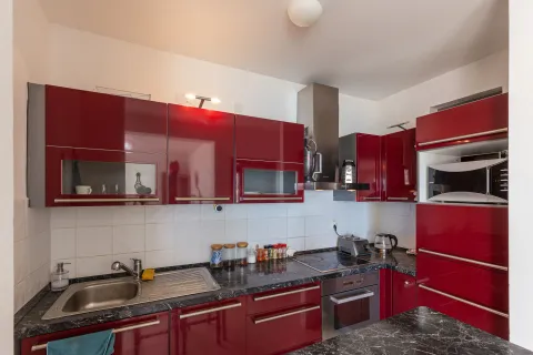 Kuhinja sa sjajnim crvenim elementima i ugrađenim kućnim aparatima. - image 9
