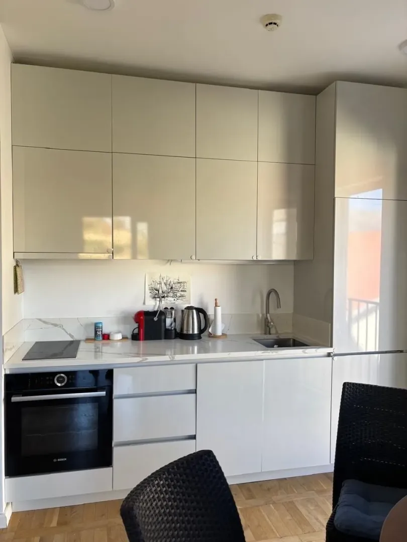 Modern kitchen with white cabinetry and built-in appliances.