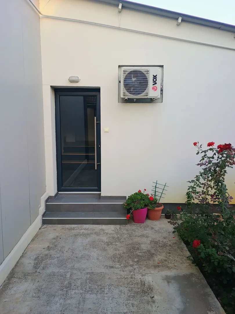 Entrance to the building with a white facade and paved yard.