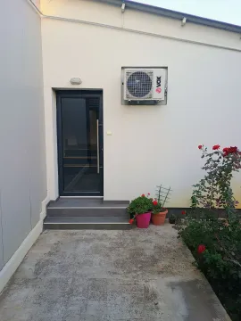 Entrance to the building with a white facade and paved yard. - image 2