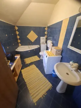 Kupatilo sa plavim pločicama, kadom, umivaonikom i veš mašinom. - image 21