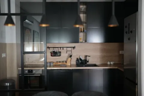 Modern kitchen with dark cabinets and wooden details. - image 4