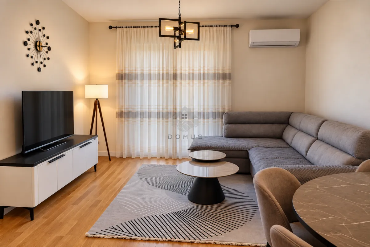 Living room with a sectional sofa, television, and dining table.