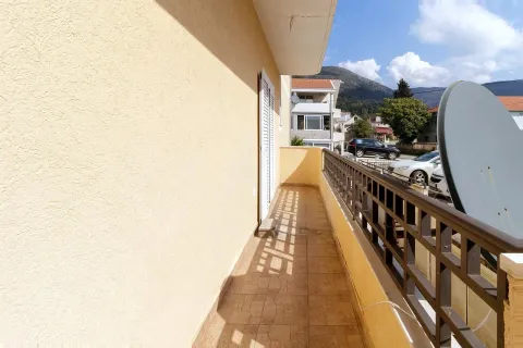 Prostrani popločani balkon sa metalnom ogradom i pogledom na ulicu i planine. - image 16