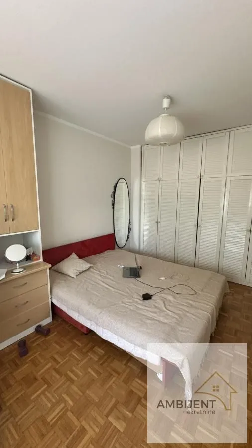 Bedroom with a double bed, large wardrobe, and parquet flooring.