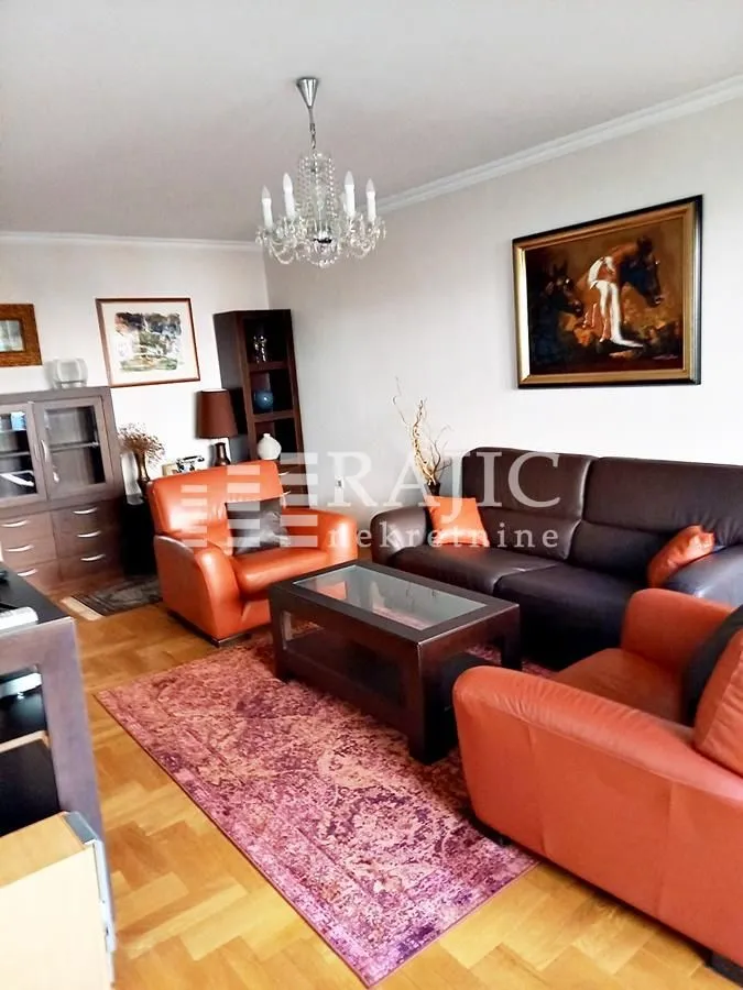 Living room furnished with seating sets, a coffee table, and cabinetry.