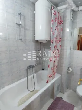 Small equipped bathroom with a bathtub and a water heater. - image 6