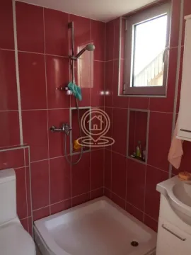 Kupatilo sa tuš kabinom obloženo crvenim pločicama. - image 15