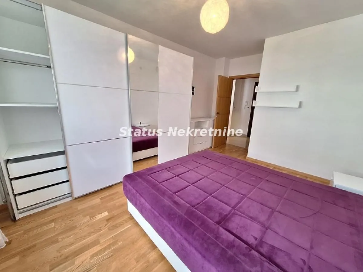 Spavaća soba sa velikim bračnim krevetom i ugradnim ormanom.